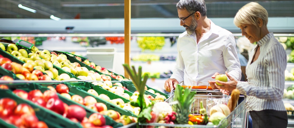 Man and woman examining fresh colorful produce at a supermarket